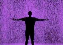 Man raising arms in rain