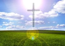 Field of green grass with cross in clouds